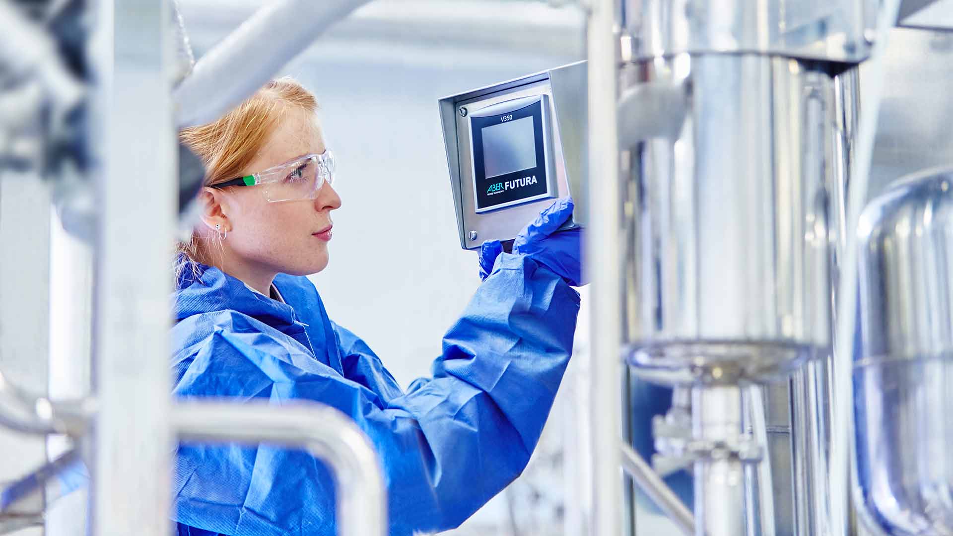 women in production facility or lab working with stainless steel equipment and an aber futura